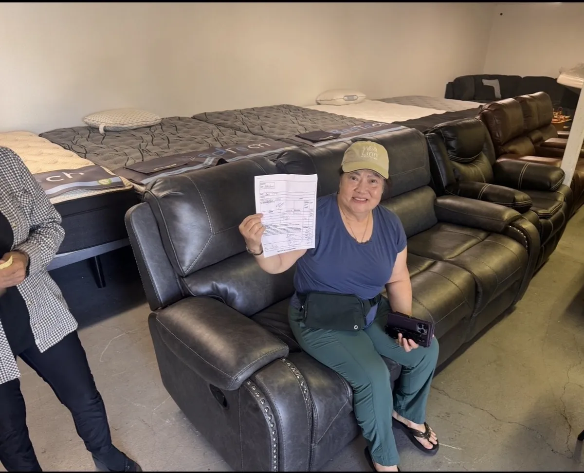 Customer with her new reclining sofa at our Elk Grove furniture and mattress showroom